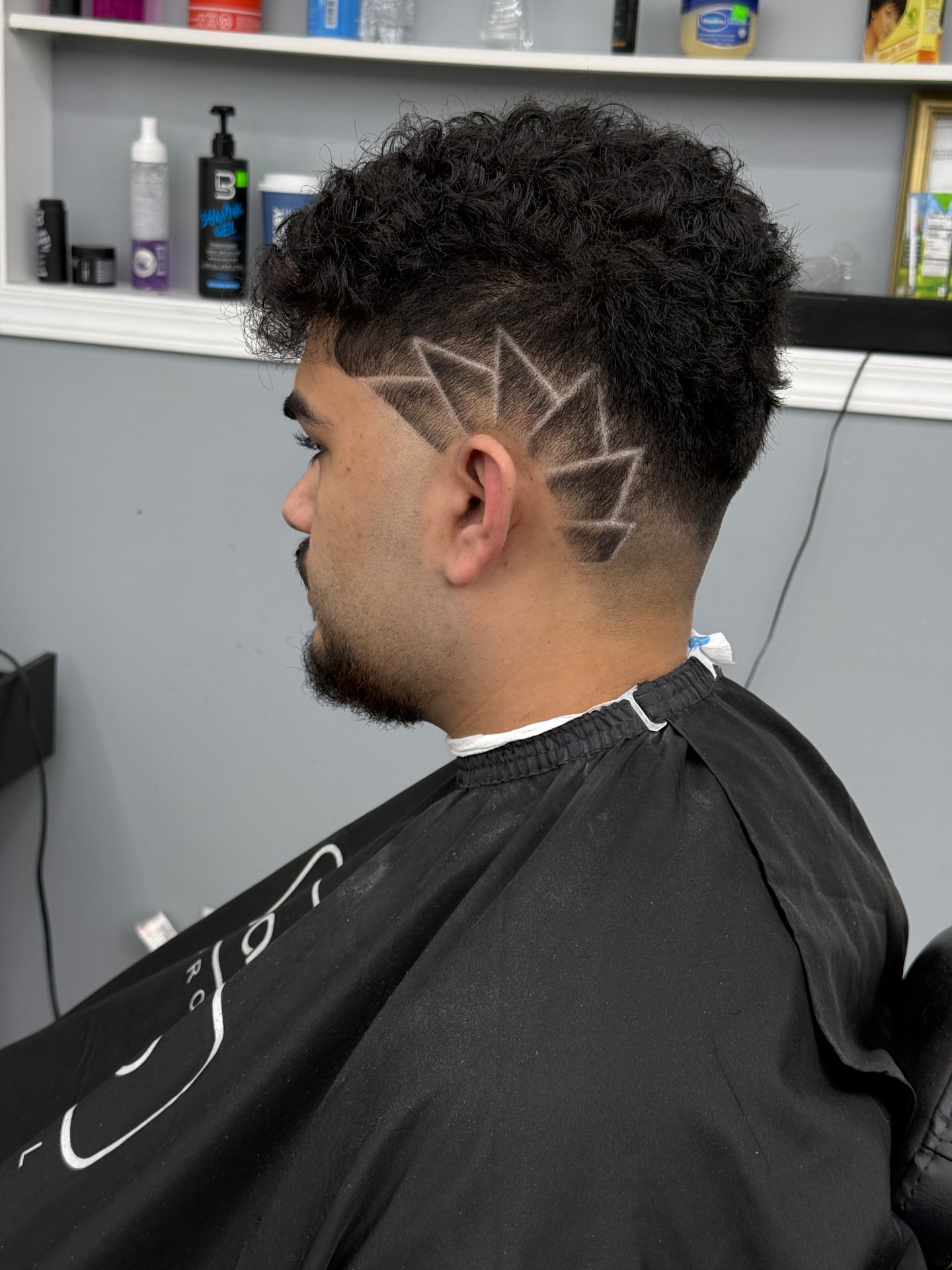 Curly top with a geometric shaved design